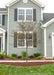 A newly planted single trunk Royal Raindrops Crabapple in a front landscape bed with bare branches with newly emerging leaves just beginning to appear.